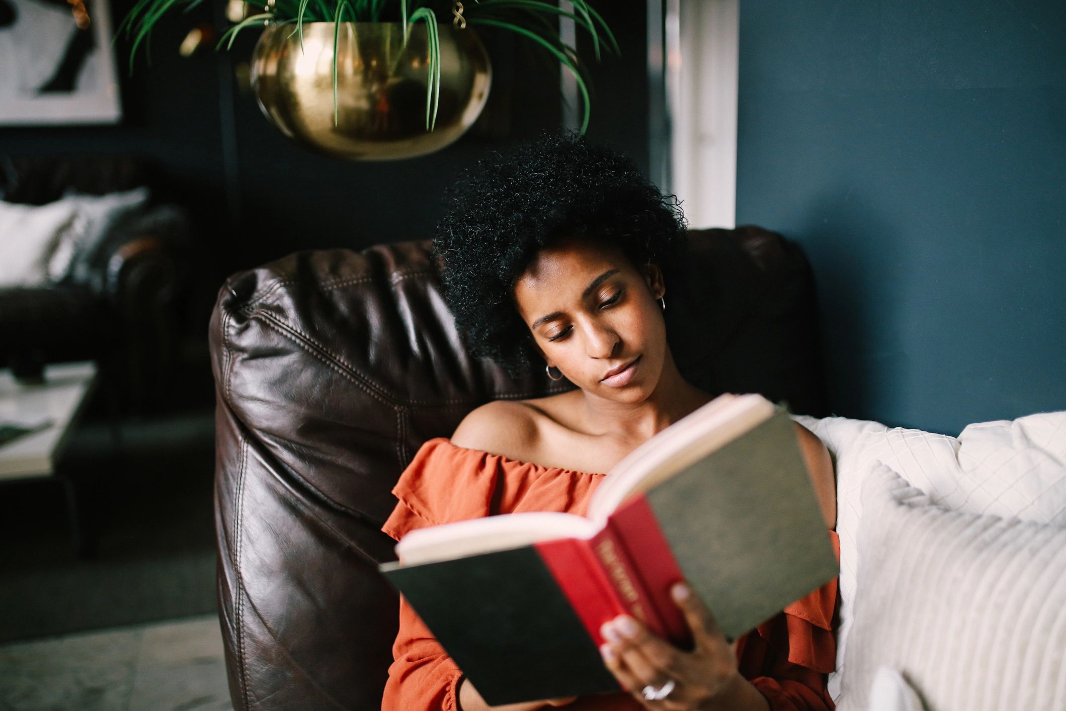 Person relaxing and reading a book in warm natural light